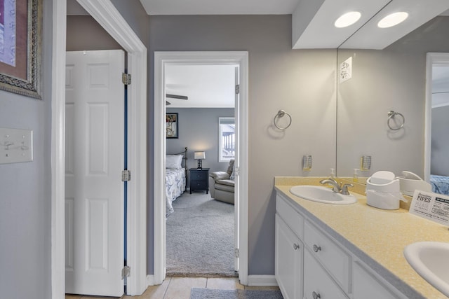 bathroom featuring double vanity, tile patterned floors, a sink, and connected bathroom