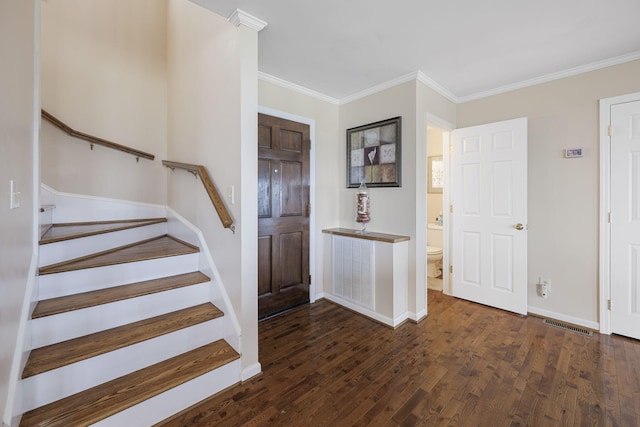 entrance foyer featuring dark wood-style floors, ornamental molding, baseboards, and stairs