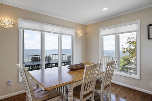 dining space featuring dark wood-style floors, a water view, crown molding, and baseboards