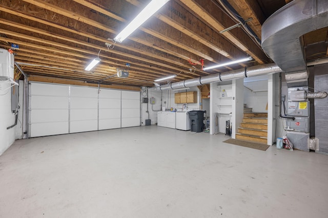 garage with heating unit and washing machine and clothes dryer