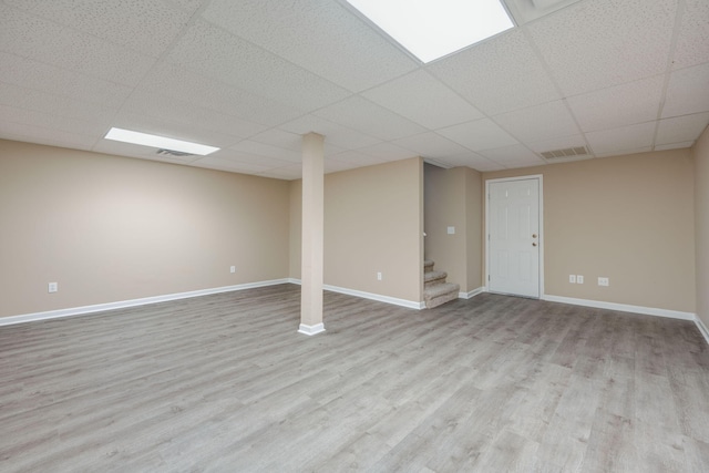 basement featuring light hardwood / wood-style floors and a drop ceiling