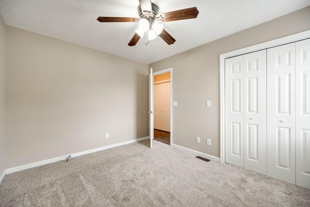 unfurnished bedroom featuring a textured ceiling, carpet, ceiling fan, and a closet