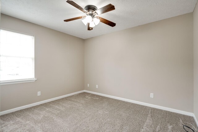 carpeted spare room featuring ceiling fan and a textured ceiling