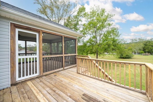 deck with a yard and a sunroom