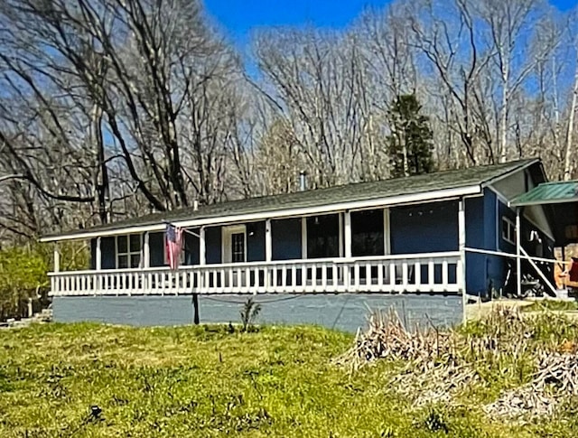 view of front of property featuring a front yard and a sunroom