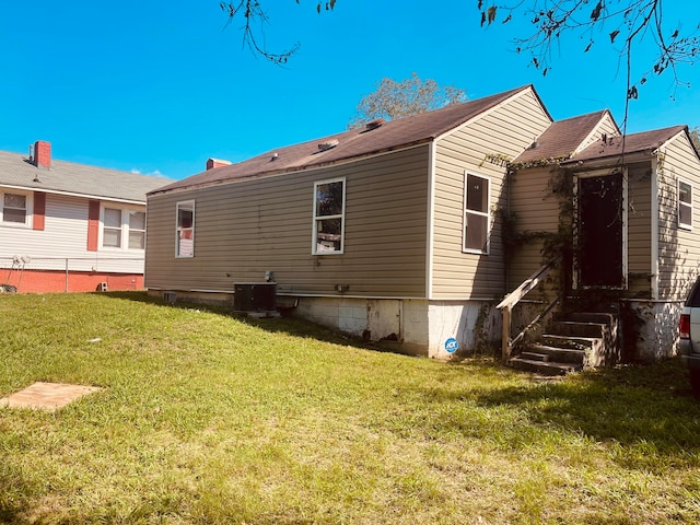 back of property with a lawn and central AC