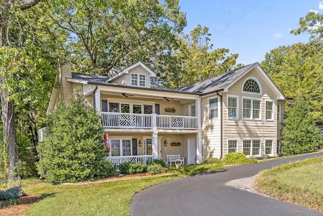 view of front of house featuring a balcony, ceiling fan, a front yard, and a porch