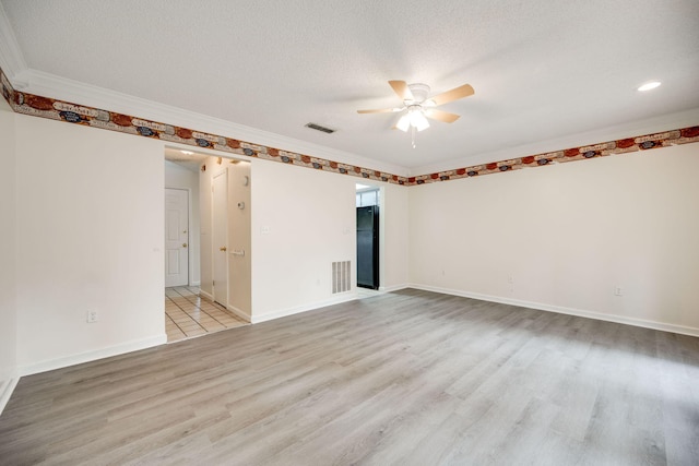 empty room with a textured ceiling, light hardwood / wood-style floors, and ceiling fan