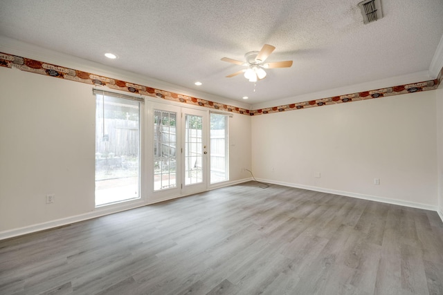 unfurnished room featuring french doors, crown molding, light wood-type flooring, a textured ceiling, and ceiling fan