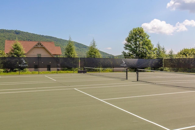 view of tennis court featuring a mountain view