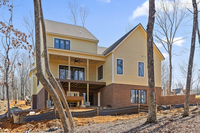 back of property with a ceiling fan, brick siding, and a balcony