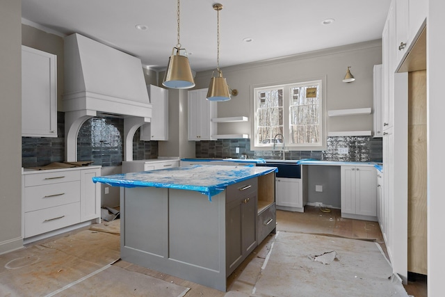 kitchen with a center island, open shelves, tasteful backsplash, light countertops, and white cabinetry