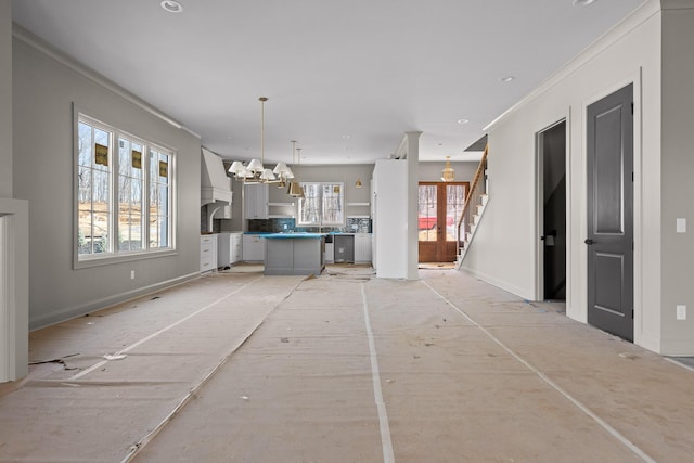 interior space featuring an inviting chandelier, stairs, and baseboards