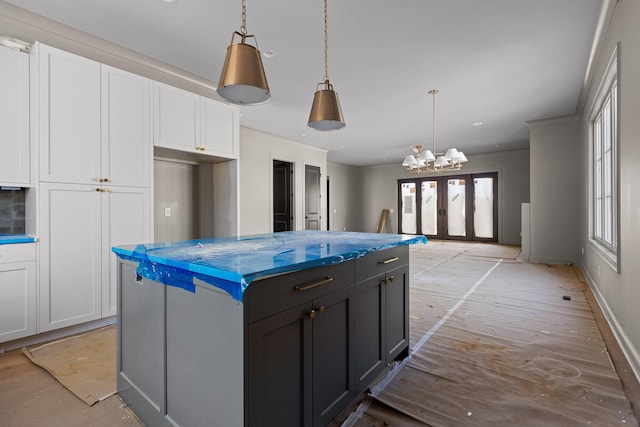 kitchen with a center island, decorative light fixtures, and white cabinets