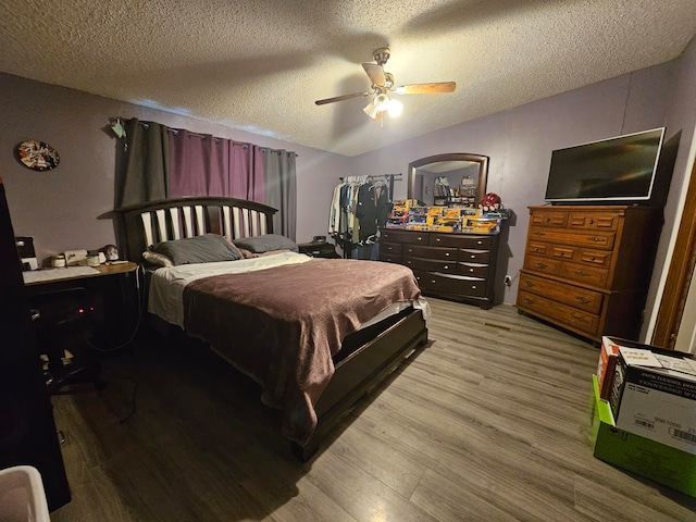 bedroom featuring ceiling fan, a textured ceiling, and light hardwood / wood-style floors