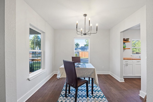 dining room featuring an inviting chandelier, dark hardwood / wood-style floors, and plenty of natural light