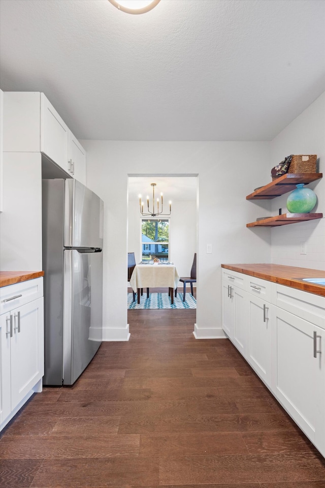 kitchen featuring white cabinets, wood counters, and stainless steel fridge