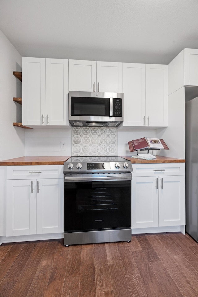 kitchen featuring backsplash, wood counters, dark hardwood / wood-style flooring, stainless steel appliances, and white cabinets