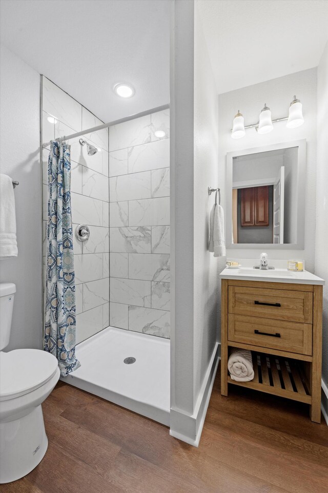 bathroom with vanity, hardwood / wood-style floors, toilet, and walk in shower