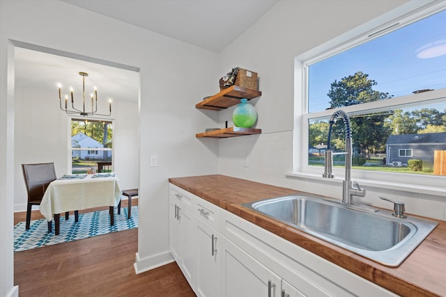 kitchen featuring a healthy amount of sunlight, wood counters, decorative light fixtures, and sink