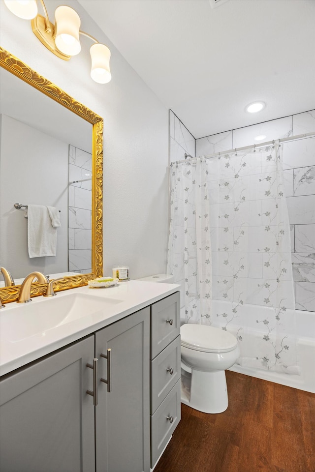 full bathroom with shower / tub combo with curtain, vanity, hardwood / wood-style flooring, and toilet