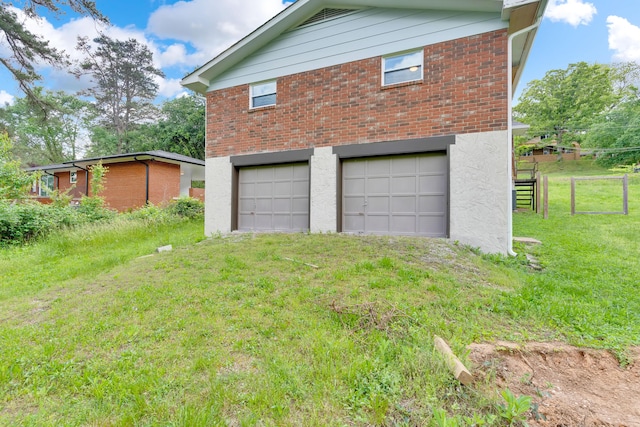 garage featuring fence and driveway