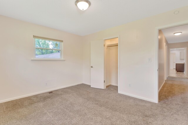unfurnished bedroom featuring a closet, baseboards, carpet flooring, and visible vents