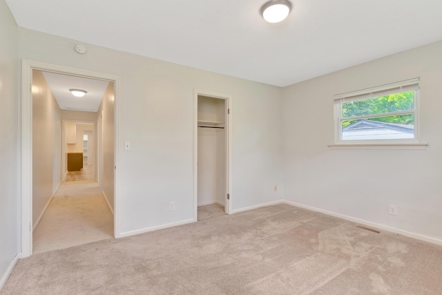 unfurnished bedroom featuring carpet floors, baseboards, a closet, and visible vents