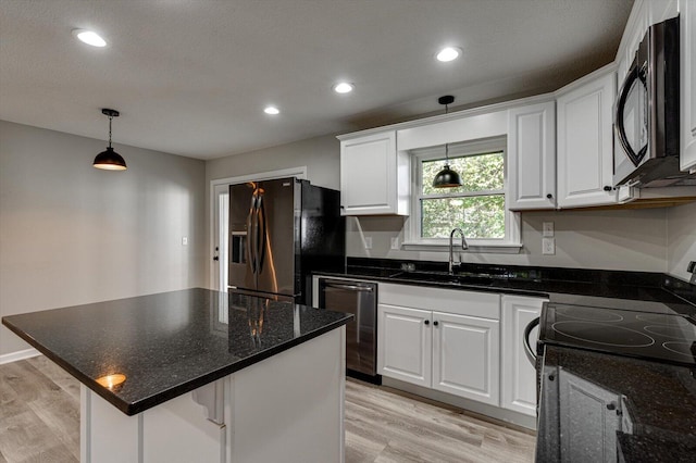 kitchen featuring a center island, sink, stainless steel appliances, and white cabinets