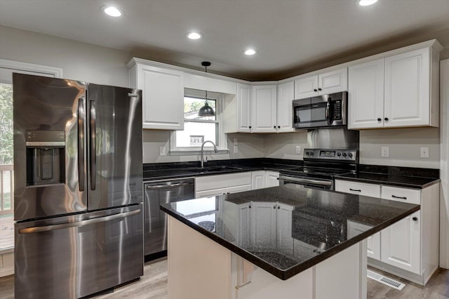 kitchen featuring white cabinets, appliances with stainless steel finishes, and a center island