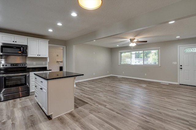 kitchen featuring stainless steel appliances, a center island, light hardwood / wood-style floors, and white cabinetry