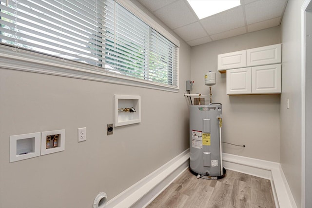 washroom featuring light wood-type flooring, hookup for a washing machine, hookup for an electric dryer, electric water heater, and cabinets