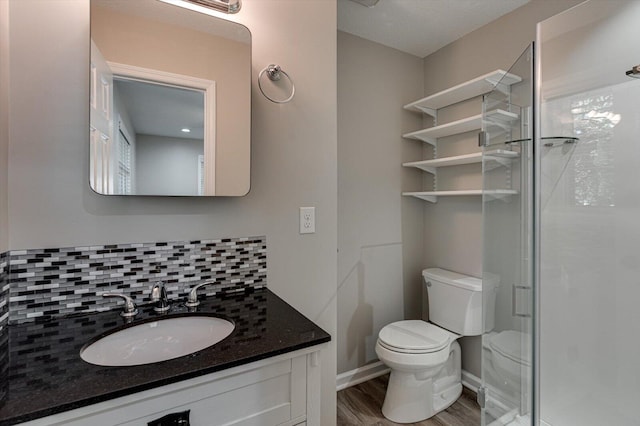 bathroom featuring vanity, tasteful backsplash, an enclosed shower, wood-type flooring, and toilet