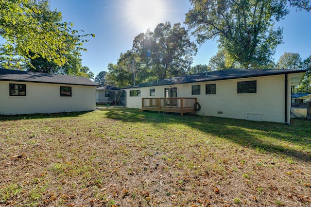 rear view of house with a wooden deck and a yard