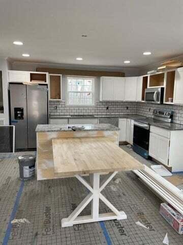 kitchen featuring white cabinetry, appliances with stainless steel finishes, and decorative backsplash