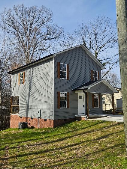 view of front of property featuring a front yard and cooling unit