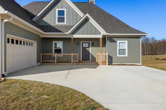 craftsman-style home featuring a shingled roof, board and batten siding, a porch, a chimney, and concrete driveway