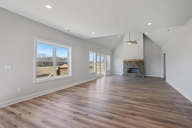 unfurnished living room with light hardwood / wood-style floors, high vaulted ceiling, a fireplace, and ceiling fan