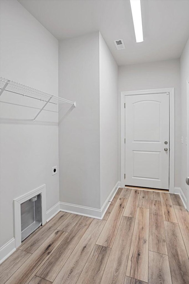 laundry room with light hardwood / wood-style flooring and hookup for an electric dryer