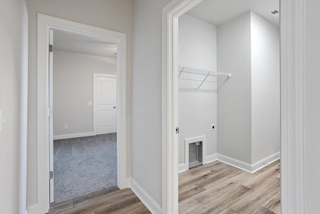 laundry area with electric dryer hookup and light hardwood / wood-style floors