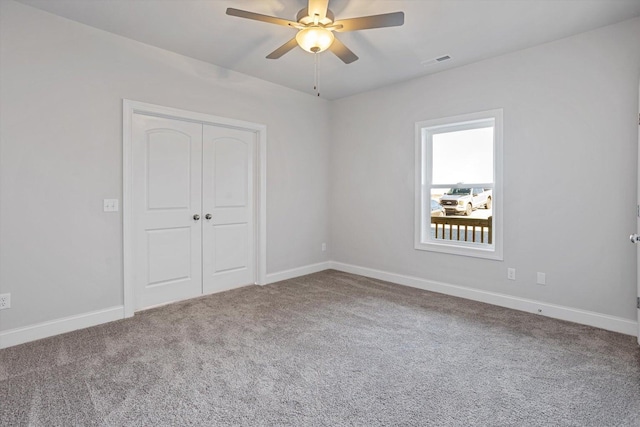 unfurnished bedroom with a closet, carpet flooring, and ceiling fan