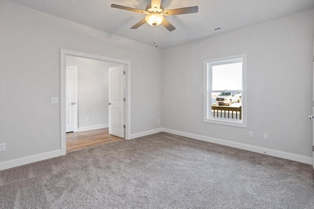 carpeted spare room featuring ceiling fan