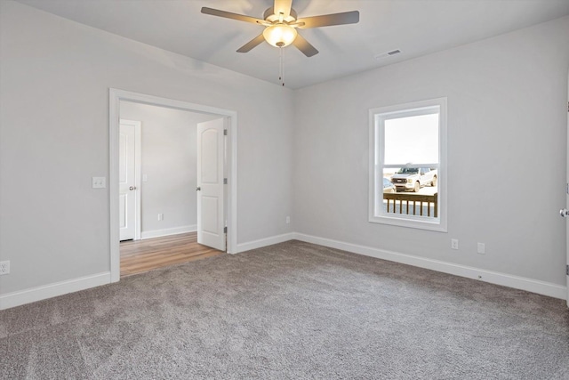 empty room featuring baseboards, carpet, a ceiling fan, and visible vents