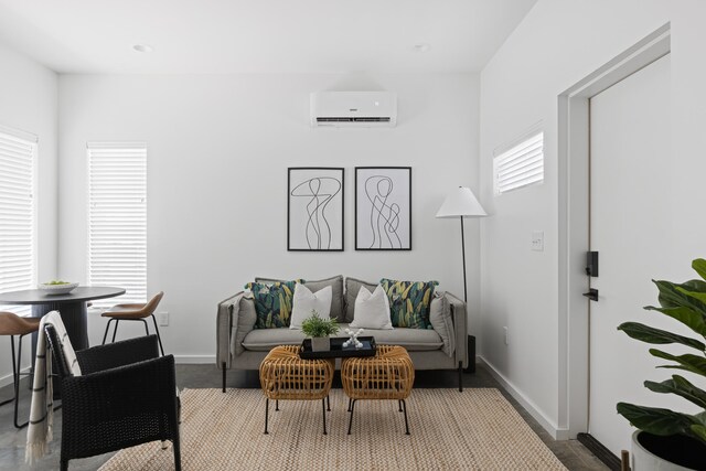 living room with an AC wall unit and a healthy amount of sunlight