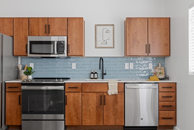 kitchen with appliances with stainless steel finishes, sink, and tasteful backsplash