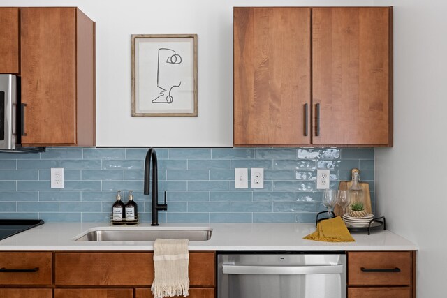 kitchen featuring tasteful backsplash, appliances with stainless steel finishes, and sink