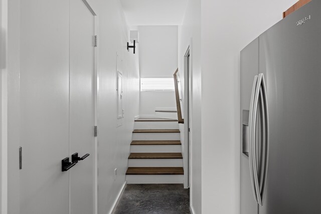 stairs featuring concrete flooring