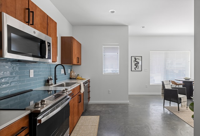 kitchen with appliances with stainless steel finishes, sink, and tasteful backsplash