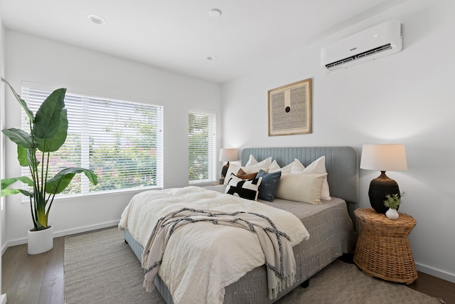 bedroom featuring an AC wall unit and hardwood / wood-style flooring