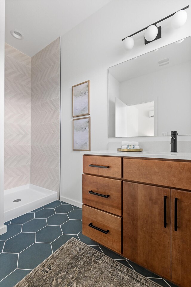 bathroom featuring tile patterned floors, walk in shower, and vanity